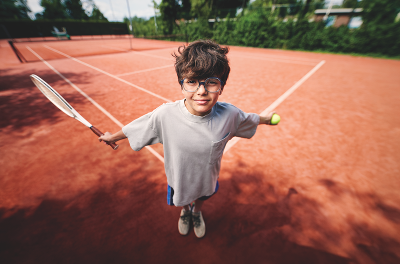 Happy child wearing glasses, running freely outdoors